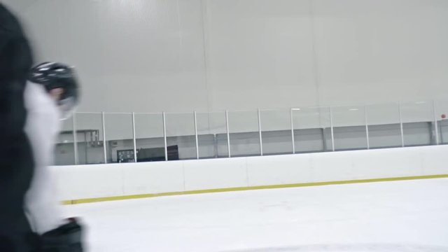 Tracking of hockey player in white uniform dribbling puck and protecting it from opponents, then scoring goal