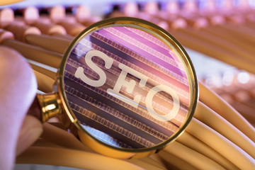 Hand Analyzing SEO Through Magnifying Glass Over Cables