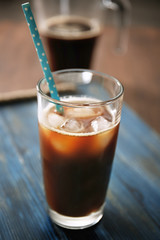 Glass with cold brew coffee and straw on table