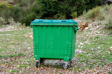  Metal green garbage can with wheels in countryside