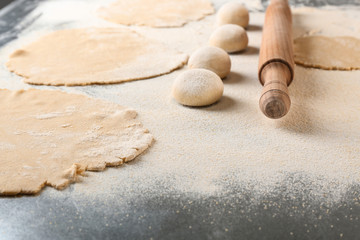 Fototapeta na wymiar Unleavened dough for tortillas with rolling pin on kitchen table