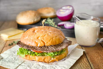 Tasty homemade burger on wooden table