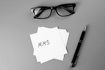 Paper sheets with written abbreviation, pen and glasses on grey background. Management concept © Africa Studio
