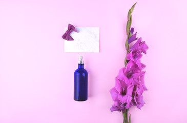 Fragrant perfume bottle with beautiful gladiolus flowers.