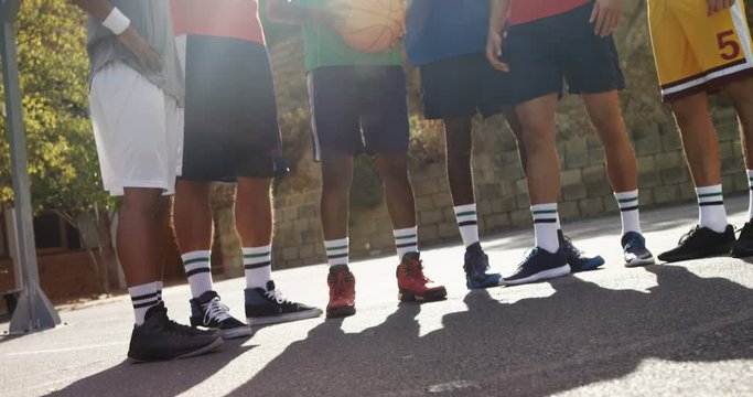 Basketball players standing together in basketball court outdoors