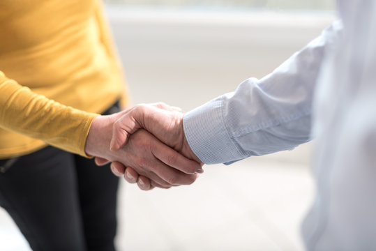 Woman and man shaking hands in office