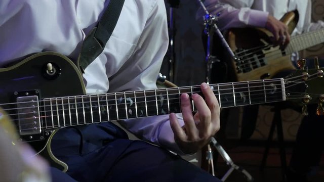 Guitarist Playing Electro Guitar on the background of Bass guitar player Slow Motion Effect . Close-up
