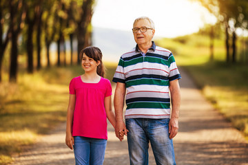 Happy grandfather and granddaughter spending time together in nature.