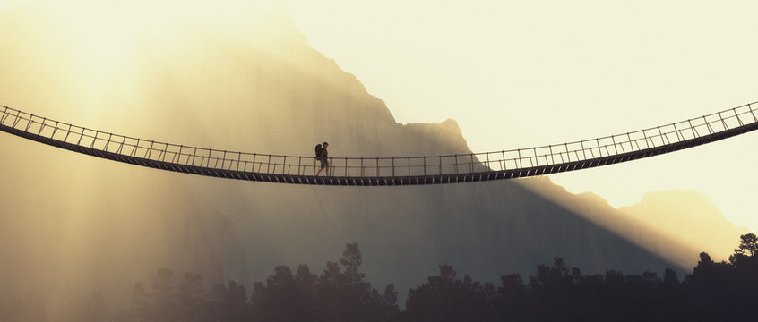 Man with backpack on a rope bridge