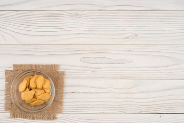 Goldfish cracker in a glass bowl on a white wooden table.