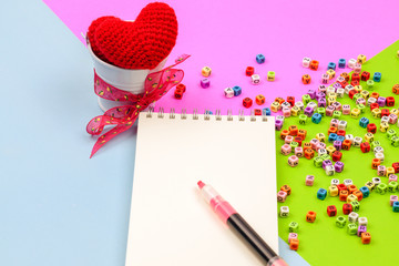 Open notepad with a pen on colorful background