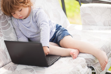 Smart toddler girl using laptop computer, child and technology