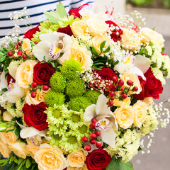 woman received a beautiful bouquet of red and beige roses, chrysanthemums and other flowers outdoors, close-up. Love and happiness concept