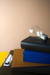 idea bulb light with books and color background
