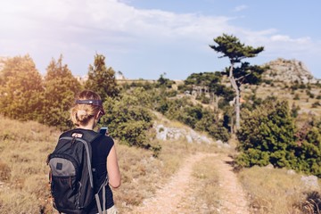 Young woman with backpack at mountain trail.