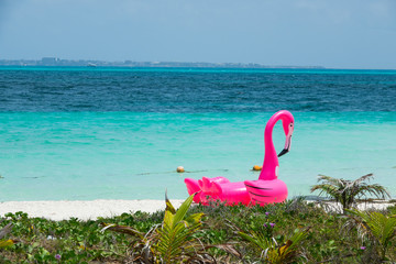 Różowy dmuchany flaming na plaży w Meksyku - obrazy, fototapety, plakaty