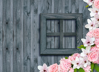 Roses, hortensia and magnolia flowers on background of shabby wooden wall and window