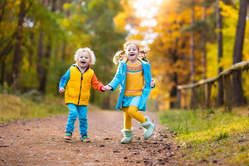 Kids play in autumn park. Children in fall.