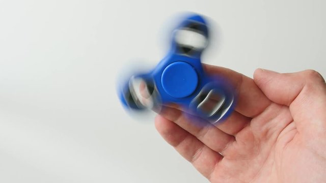 Fidget spinner isolated over white background with spinning motion blur and rotation trails. Top view.