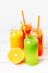 Fresh detox juices in glass bottles on white background