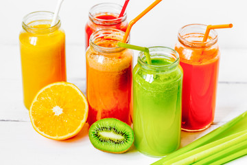 Fresh detox juices in glass bottles on white background