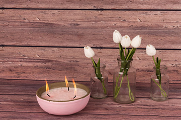 Tulipanes blancos y vela rosa.