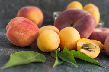 Apricot fruits, nectarine, peach and raspberries and green leaves