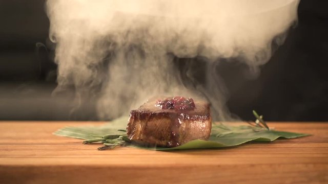 chef cooks food in the kitchen. finishing meal teasty beef steak with salad for guest of restaurant. final serving of dish. young expert cook beef fillet gourmet. Fry steak meat. closeup. slow motion