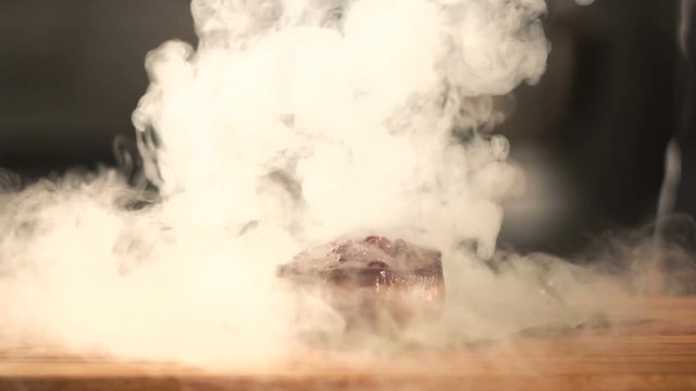 delicious piece of steak cooking on being seasoned with salt and sauce. Cooked meat on a plate. Meat with sauce and herb. Duck breast with frisee lettuce. Delicious dish and Steam. food in the kitchen