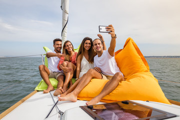 Fototapeta premium Group of friends having fun in boat in river