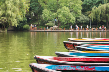 Old multicolored boats on a lake with people on the border in th