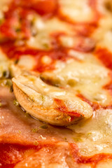 Closeup macro fresh baked round pizza with cheese ham tomato sauce mushrooms