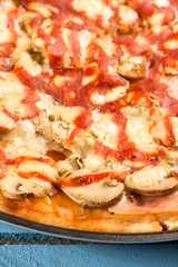 Closeup macro fresh baked round pizza with cheese ham tomato sauce mushrooms