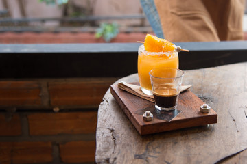 Fresh orange juice and intense Colombia coffee on wood tray served with orange grill

