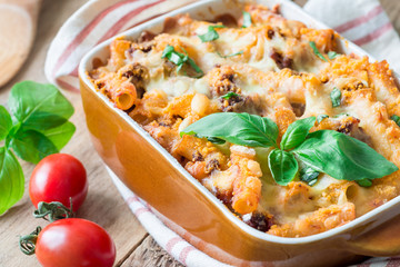Ziti bolognese in baking dish. Pasta casserole with minced meat, tomato sauce and cheese, horizontal
