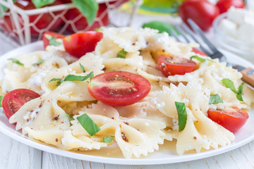 Pasta salad with tie pasta, feta cheese, tomatoes, mustard and basil, horizontal