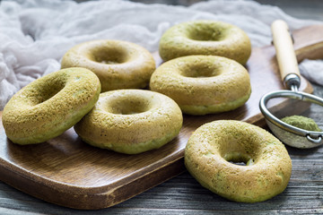 Freshly baked matcha banana donuts on wooden board
