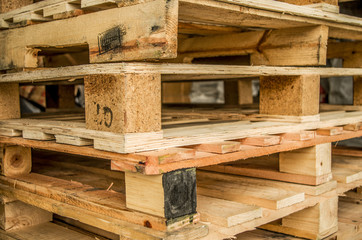 Outside stock of old manufactured wooden standard euro pallets stored in pylons