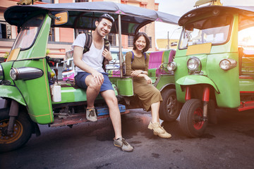 couples of young traveling people sitting on tuk tuk bangkok thailand - obrazy, fototapety, plakaty