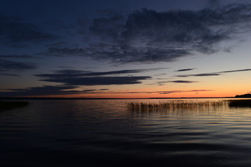 Fototapeta premium Pink strip afterglow of sunset on the horizon comes night