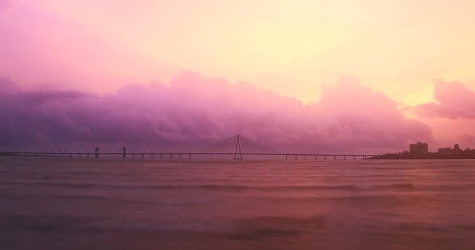 Evening to night shot of Bandra- Worli sea link (bridge) over the Arabian sea with the cloud formation and changing skyline in the background, Mumbai, india