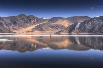 Reflection of Mountains on Pangong Lake with blue sky background. Leh, Ladakh, India.   © Sakrapee Nopparat