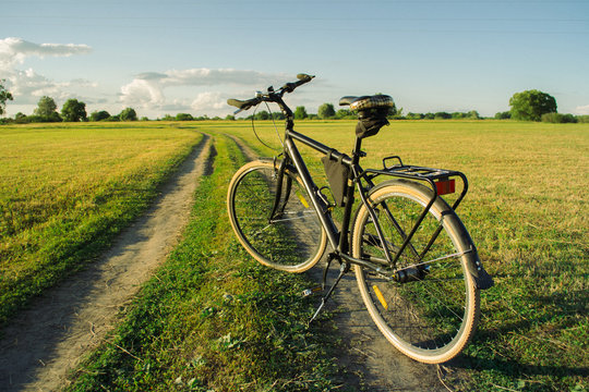 Photo of a bicycle standing on a path in the meadow