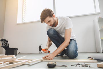 Young man does apartment repairment himself indoors
