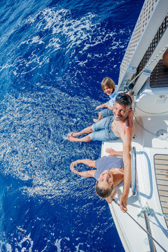 Father with adorable kids resting on yacht