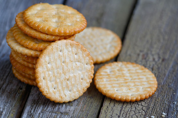 Stack of a of salted crackers on an old wooden table.
