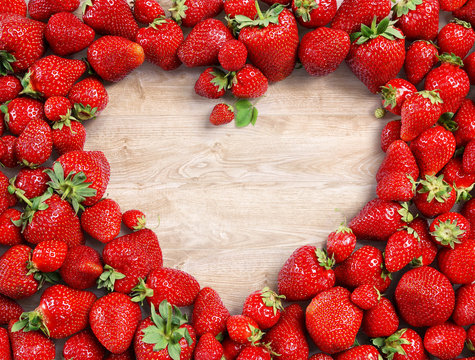 Heart shaped made of strawberry on wooden background. Fruits diet concept. Close up. Top view. High resolution