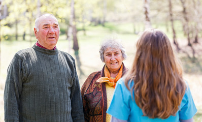 Elderly couple and young caregiver
