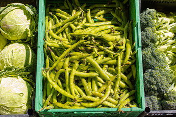 Green beans and peas in a box at a market in Italy