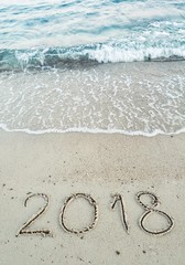 Number 2018 written on the sand at the beach